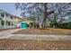 Single-story home with teal garage door and mature landscaping at 335 Tucker St, Safety Harbor, FL 34695