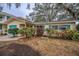 Single-story home with a teal garage door and well-maintained landscaping at 335 Tucker St, Safety Harbor, FL 34695