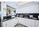 White kitchen with granite countertops, black tile backsplash, and ocean view at 880 Mandalay Ave # S507, Clearwater Beach, FL 33767