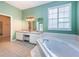 The bathroom features a soaking tub, double vanity, and plantation shutters at 1032 Rosetree Ln, Tarpon Springs, FL 34689