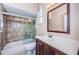 Bathroom featuring a shower-tub combo and dark wood cabinets at 1032 Rosetree Ln, Tarpon Springs, FL 34689
