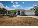 Charming home featuring a well-manicured lawn, a two-car garage, and double door front entry at 1032 Rosetree Ln, Tarpon Springs, FL 34689