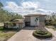 Two-story house with stone exterior, paved driveway, and circular landscaping at 10073 S Yacht Club Dr, Treasure Island, FL 33706
