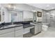 Modern bathroom with double vanity, black countertop, and walk-in shower at 10073 S Yacht Club Dr, Treasure Island, FL 33706