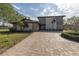 Two-story house with stone exterior, paved driveway, and lush landscaping at 10073 S Yacht Club Dr, Treasure Island, FL 33706