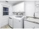 Laundry room with washer, dryer, and white cabinets at 10073 S Yacht Club Dr, Treasure Island, FL 33706