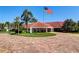 Community clubhouse entrance with a flag and lush landscaping at 8001 Sailboat Key S Blvd # 204, St Pete Beach, FL 33707
