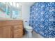 Clean bathroom with light wood cabinets and a blue shower curtain at 6268 Palma Del Mar S Blvd # 406, St Petersburg, FL 33715