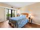 Cozy bedroom with a full-size bed and sliding glass doors to balcony at 830 S Gulfview Blvd # 102, Clearwater, FL 33767