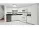 White kitchen features stainless steel appliances and dark countertops at 3051 Overlook Pl, Clearwater, FL 33760