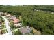 Aerial view showcasing a house nestled in a wooded area with a pool at 4995 Quill Ct, Palm Harbor, FL 34685