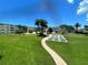 Landscaped community grounds with mature palm trees, shuffleboard court, and lush green lawn at 6201 2Nd E St # 73, St Pete Beach, FL 33706