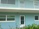 A charming exterior view showcasing the building's facade with a door, windows, and a balcony, all freshly painted at 6201 2Nd E St # 73, St Pete Beach, FL 33706