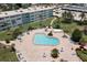 Amazing aerial view of the community pool surrounded by tropical landscaping and lounge chairs at 6201 2Nd E St # 73, St Pete Beach, FL 33706