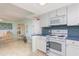 Bright kitchen with white appliances and blue mosaic backsplash at 1 Key Capri # 102E, Treasure Island, FL 33706