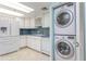Kitchen with white cabinets, mosaic backsplash and stackable washer/dryer at 1 Key Capri # 102E, Treasure Island, FL 33706