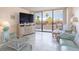 Bright living room with patio access, comfortable seating, and large TV at 1 Key Capri # 102E, Treasure Island, FL 33706