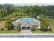 Aerial view of community pool, lounge chairs, umbrellas, and lush tropical landscaping at 13856 Royston Bnd, Hudson, FL 34669