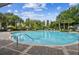 Large community pool with ample seating, lounge chairs, and lush tropical landscaping at 13856 Royston Bnd, Hudson, FL 34669