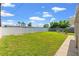 Fenced backyard with green lawn and concrete patio at 4031 Reggie Dr, Holiday, FL 34691