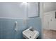 Simple half bathroom with light blue tile and a single sink at 4031 Reggie Dr, Holiday, FL 34691