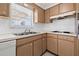 Cozy kitchen with wood cabinets, double sink, and a window overlooking the backyard at 4031 Reggie Dr, Holiday, FL 34691