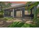 Backyard view of a screened porch with a built-in grill at 131 Pennsylvania Ave, Palm Harbor, FL 34683