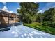 View of the lush green backyard with a white patio and screen room, perfect for outdoor entertaining at 3482 Rolling Trl, Palm Harbor, FL 34684