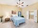 Bright bedroom with tile flooring, a ceiling fan, and an en-suite bathroom at 3482 Rolling Trl, Palm Harbor, FL 34684