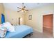 Cozy bedroom with tile flooring, a ceiling fan, and access to an en-suite bathroom and walk-in closet at 3482 Rolling Trl, Palm Harbor, FL 34684