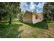 Exterior view of home with a large backyard and partial view of the screened porch and outdoor patio area at 3482 Rolling Trl, Palm Harbor, FL 34684