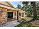 Front entrance featuring a black double door, brick column, and a manicured lawn, creating an inviting welcome at 3482 Rolling Trl, Palm Harbor, FL 34684