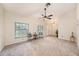 Cozy living room features plush carpet, a ceiling fan, and large windows for natural light at 3482 Rolling Trl, Palm Harbor, FL 34684