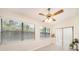 Sun-filled living room featuring large windows with blinds, a ceiling fan, tile flooring and light walls at 3482 Rolling Trl, Palm Harbor, FL 34684