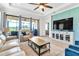 Bright and airy living room with light beige sofas and a large TV at 3134 Francoa Dr, Odessa, FL 33556