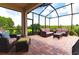 Spacious screened patio featuring wicker furniture and a view of the lush backyard at 3134 Francoa Dr, Odessa, FL 33556