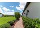 Landscaped walkway with lush greenery alongside the home's exterior at 3134 Francoa Dr, Odessa, FL 33556