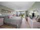 Primary bedroom with king-size bed, private balcony, and large windows at 5700 Escondida S Blvd # 306, St Petersburg, FL 33715
