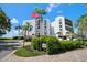 White building exterior with palm trees, landscaping, and a paved driveway at 5700 Escondida S Blvd # 306, St Petersburg, FL 33715