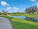 Peaceful waterfront view with lush green grass and trees at 5700 Escondida S Blvd # 306, St Petersburg, FL 33715