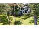 Aerial view of a two-story home with black trim, surrounded by a lush green lawn and mature trees at 5518 21St S Ave, Gulfport, FL 33707