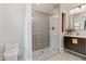 Stylish bathroom with a patterned glass shower, modern vanity, toilet, and recessed storage shelves at 5518 21St S Ave, Gulfport, FL 33707