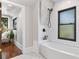 Bright bathroom featuring subway tile, a black window frame, and a tub-shower combination at 5518 21St S Ave, Gulfport, FL 33707