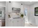 Kitchen features white cabinetry, modern pot filler over range, and stainless vent hood at 5518 21St S Ave, Gulfport, FL 33707