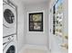 Clean laundry room featuring stacked washer and dryer with a black-framed window to outside at 5518 21St S Ave, Gulfport, FL 33707