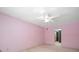 Pink bedroom with ceiling fan and access to bath at 3934 Venetian Way, Tampa, FL 33634