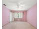 Pink bedroom with window, ceiling fan and carpeting at 3934 Venetian Way, Tampa, FL 33634