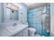 Bright bathroom featuring a white vanity and toilet, and a shower with an ocean themed blue curtain at 1235 S Highland Ave # 2-204, Clearwater, FL 33756