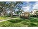 A serene walkway passes by community wooden pergola and seating amidst beautifully landscaped grounds with mature trees at 1235 S Highland Ave # 2-204, Clearwater, FL 33756