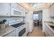 Kitchen with white appliances, granite countertops and natural light; dining area visible through kitchen at 1235 S Highland Ave # 2-204, Clearwater, FL 33756